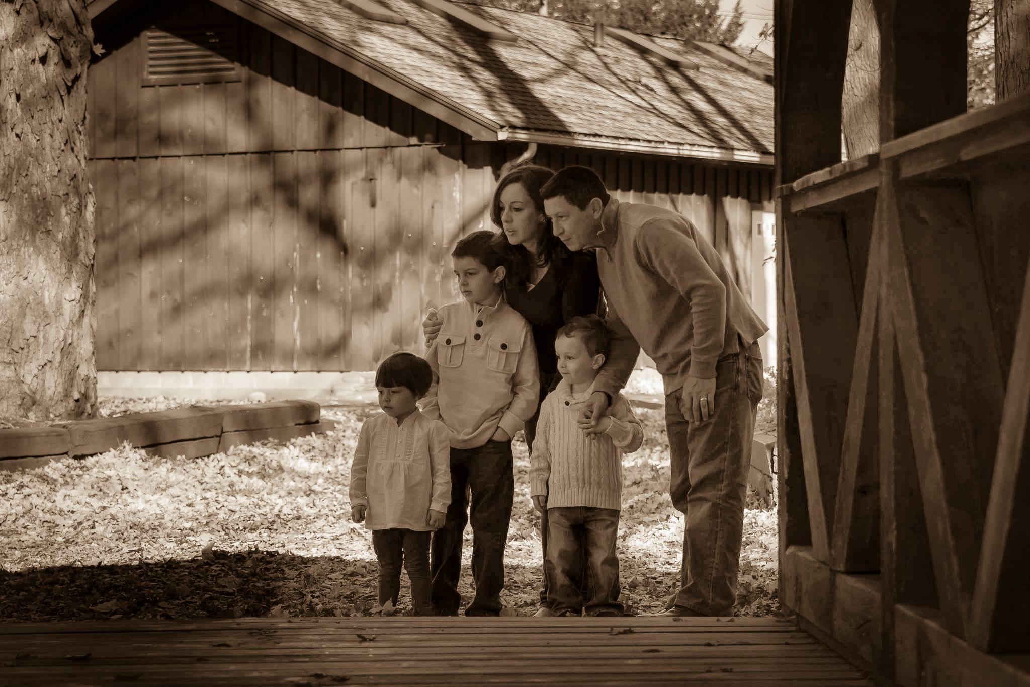 Family taking a moment to distract the kids during their session by looking over at horses in the park